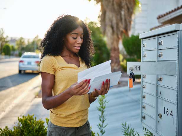 Woman reading mail at mailbox